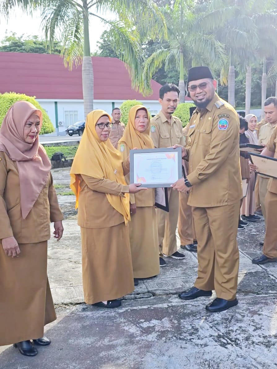Bupati Bassam Kasuba Saat Menyerahkan Piagam Penghargaan Kepada ASN Berkinerja Baik